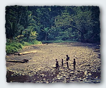 Children play on edge of their jungle river. 